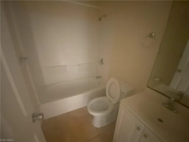 Full bath featuring vanity, shower / bath combination, and light tile patterned flooring