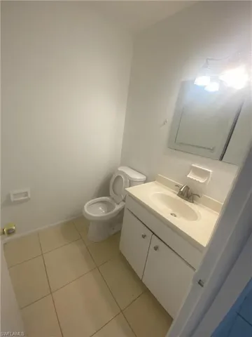 Half bathroom featuring vanity and light tile patterned flooring