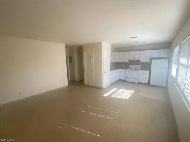 Unfurnished living room with baseboards