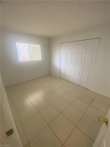 Unfurnished bedroom with light tile patterned floors and a closet