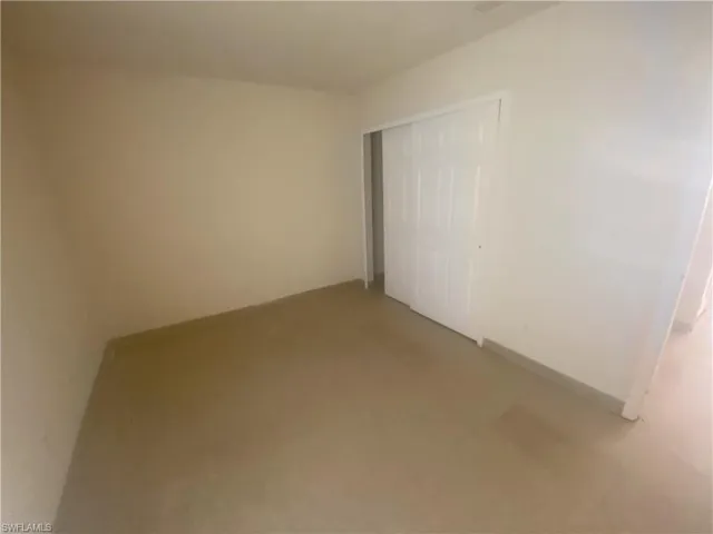 Unfurnished bedroom with a closet and baseboards