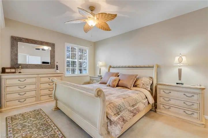Bedroom with a ceiling fan and light carpet