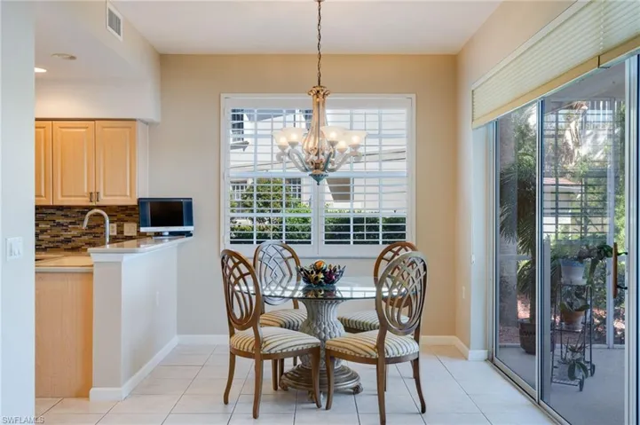 Dining area with light tile patterned floors and suspended lighting