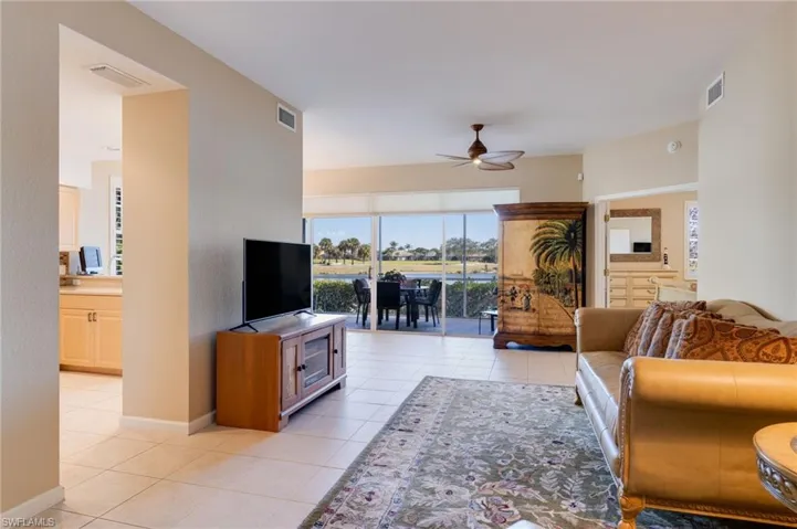 Living room with a ceiling fan and light tile patterned floors