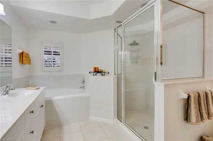 Bathroom with vanity, a stall shower, a bath, and light tile patterned floors