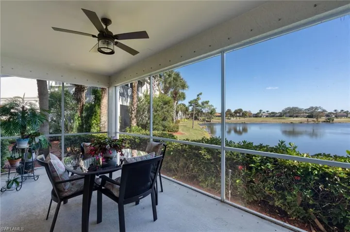Sunroom with a ceiling fan, outdoor dining space, and a water view