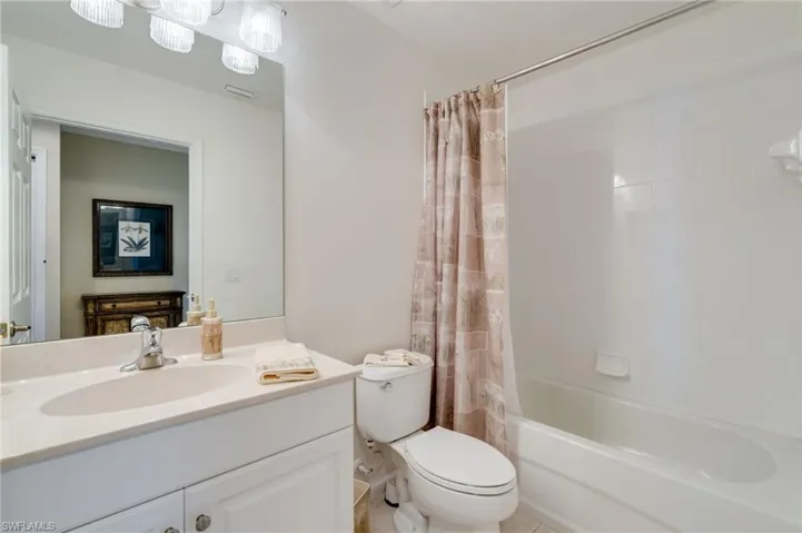 Bathroom featuring vanity and shower / bathtub combination with curtain
