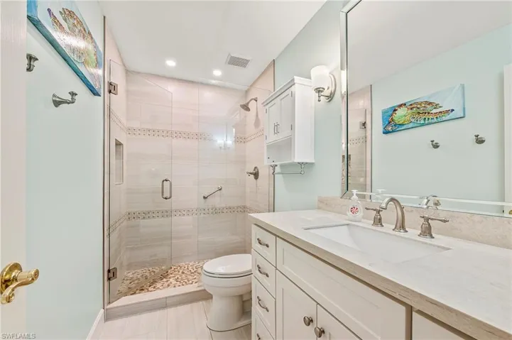 Bathroom with tile patterned flooring, vanity, toilet, and walk in shower