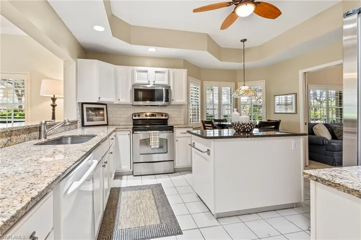 Kitchen with white cabinets, appliances with stainless steel finishes, a wealth of natural light, and sink