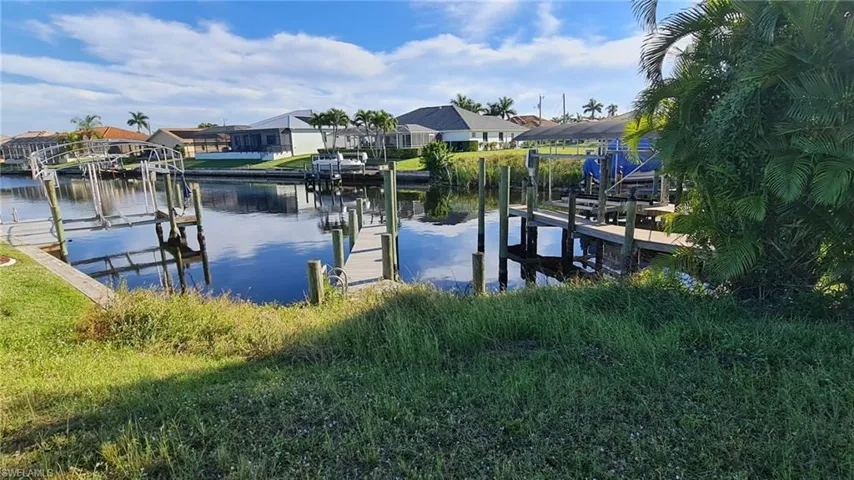 Dock featuring a water view, boat lift, and a residential view