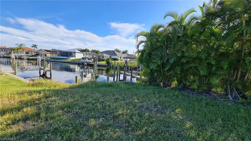Dock featuring boat lift, a water view, and a residential view