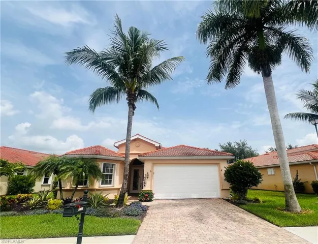Mediterranean / spanish-style home featuring a garage and a front lawn
