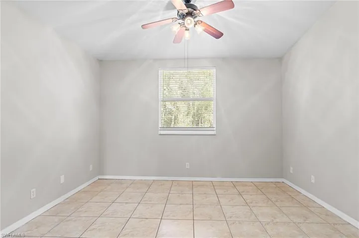 Unfurnished room with light tile patterned flooring and ceiling fan
