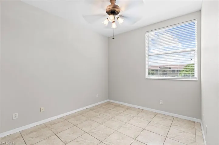 Spare room with light tile patterned flooring and ceiling fan