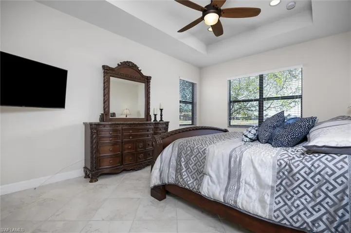 Bedroom featuring a raised ceiling, a ceiling fan, and recessed lighting
