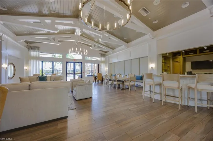 Living area featuring suspended lighting, a high ceiling, and wood finished floors