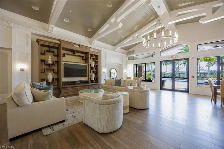 Living room with french doors, a high wood beamed ceiling, wood finished floors, and suspended lighting