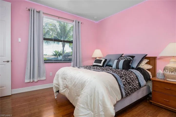 Bedroom with wood-type flooring and baseboards