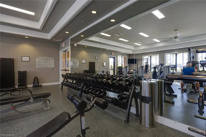 Gym featuring a tray ceiling and ceiling fan