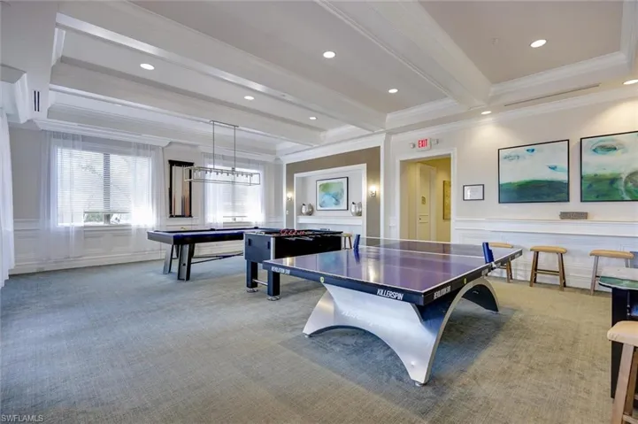 Recreation room featuring a wainscoted wall, a decorative wall, crown molding, and billiards