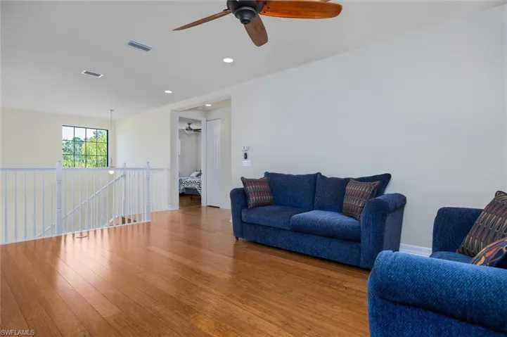 Living area featuring wood-type flooring, a ceiling fan, and recessed lighting