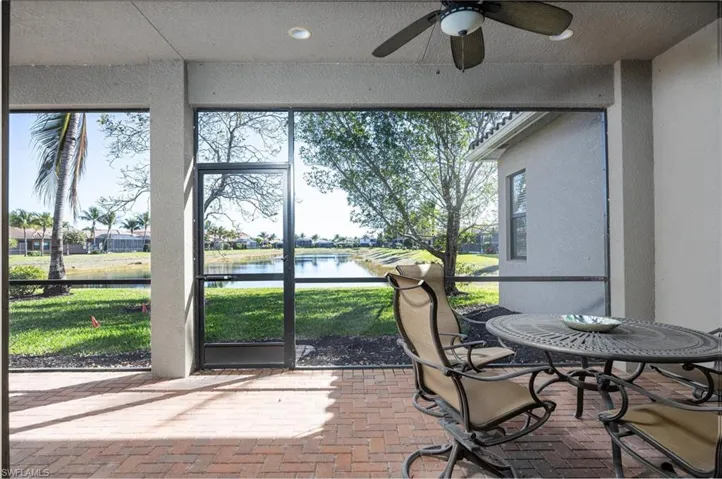 Sunroom / solarium with a ceiling fan, a patio area, and a water view