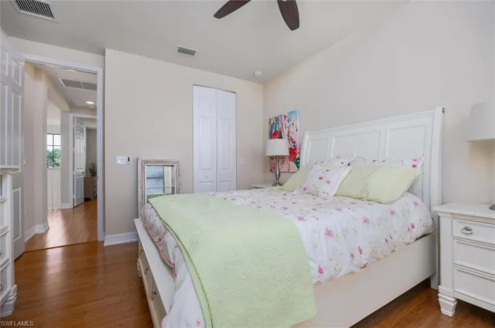 Bedroom featuring dark wood-style floors, a closet, and a ceiling fan