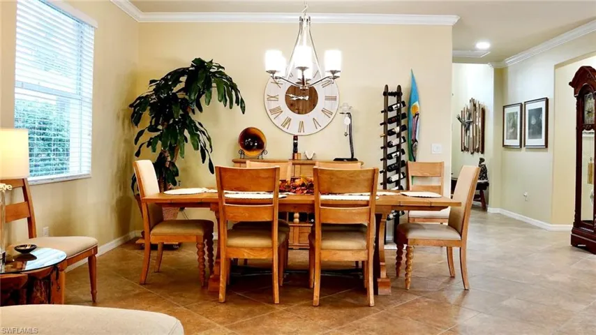 Dining room featuring crown molding, a chandelier, and light tile patterned floors