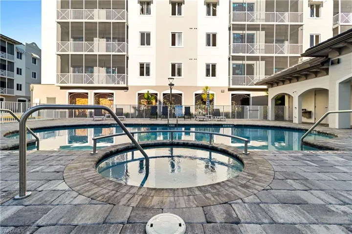 Outdoor pool and spa area featuring a gray paver surround