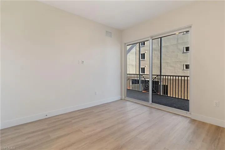 Expansive sliding glass doors opening to a private balcony with black metal railings