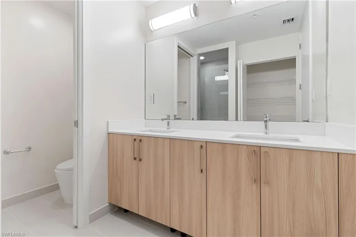 Dual vanity with wood-finish cabinetry and chrome hardware