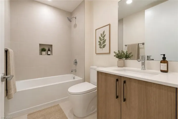 Bathroom featuring a wood-finish vanity with a white countertop and integrated sink