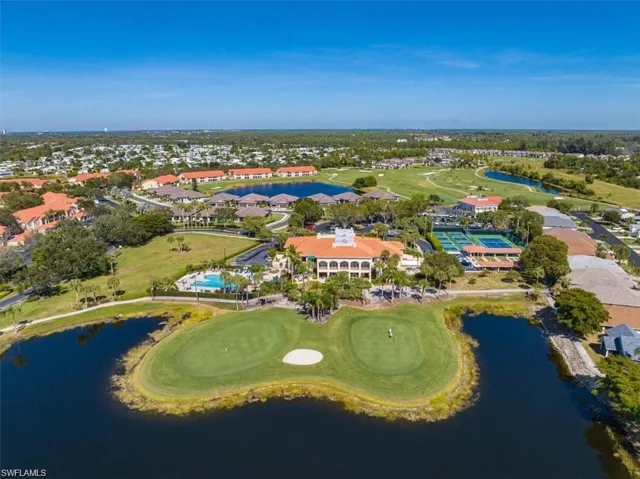 Expansive golf course and water features bordering a community with multiple residential buildings