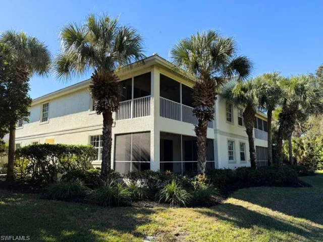 Rear view of property with a sunroom, a yard, a balcony, and stucco siding