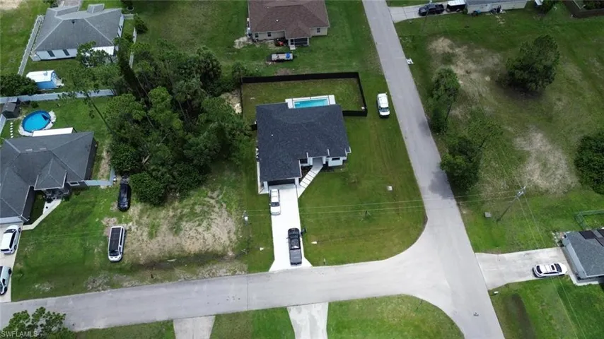 Aerial view of property and surrounding area featuring nearby suburban area