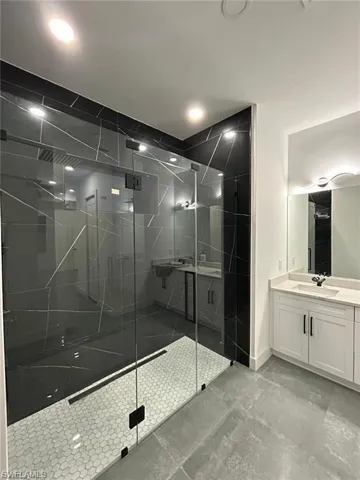 Full bathroom featuring vanity, a shower stall, and recessed lighting