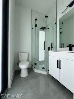 Bathroom with vanity and a marble finish shower