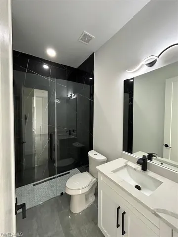 Full bathroom with vanity and a marble finish shower