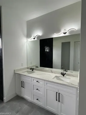 Full bathroom with double vanity and toilet