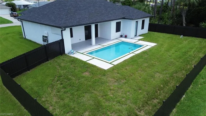 View of swimming pool with a patio and a fenced backyard