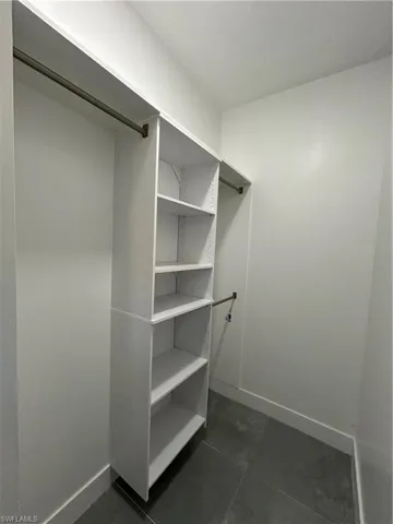 Walk in closet with dark tile patterned flooring