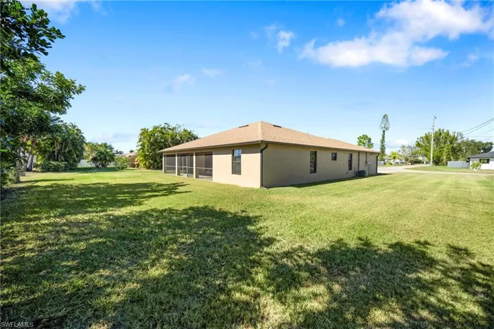 View of property exterior featuring a lawn, stucco siding, and a sunroom