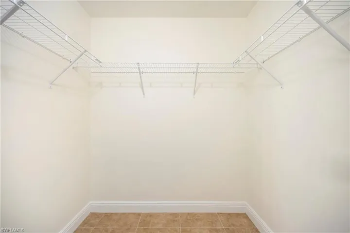 Walk in closet with light tile patterned floors