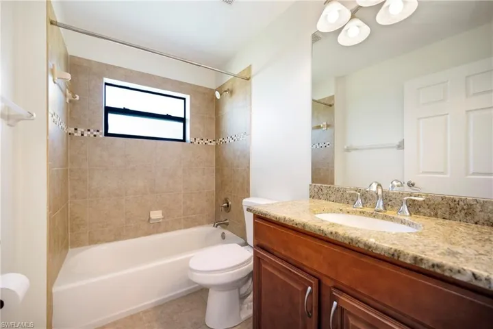Full bath featuring tub / shower combination, vanity, and light tile patterned flooring