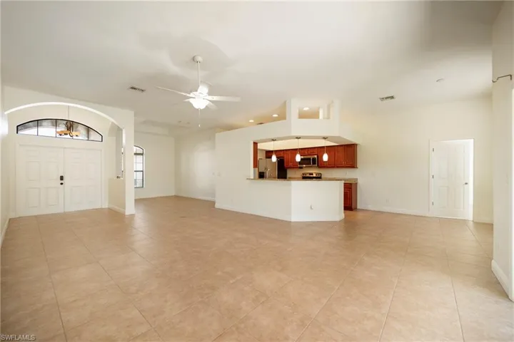 Unfurnished living room featuring a ceiling fan and light tile patterned flooring