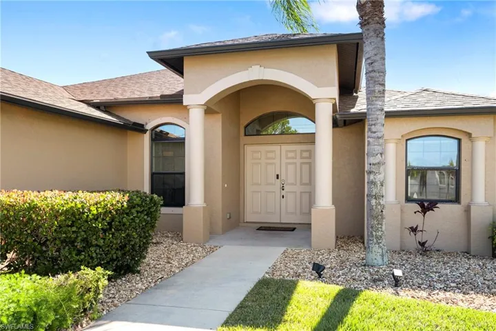 Entrance to property featuring stucco siding and a shingled roof