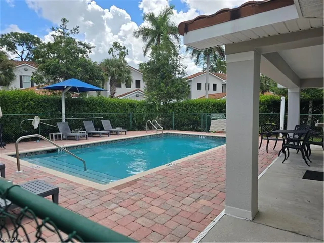 Relax at the Outdoor pool with brick paver surround, integrated entry steps, and metal handrails