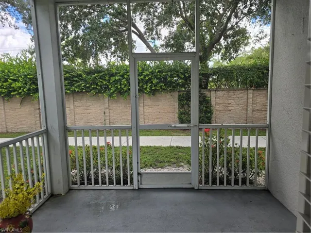 Screened porch featuring a concrete floor, white aluminum framing, and a screened door