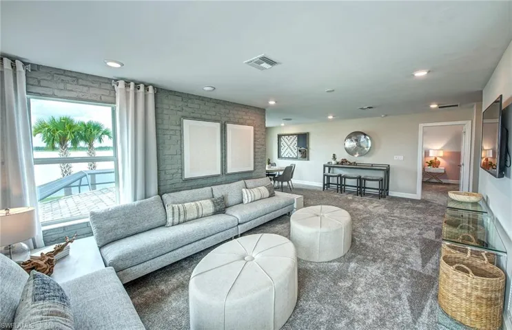 Carpeted living room featuring brick wall