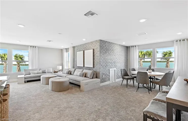Carpeted living room with a fireplace and a water view